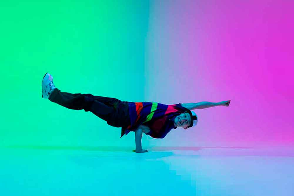 beautiful-sportive-boy-dancing-hip-hop-in-stylish-clothes-on-colorful-gradient-wall-at-dance-hall-in-neon-light-youth-culture-movement-style-and-fashion-action-fashionable-bright-portrait
