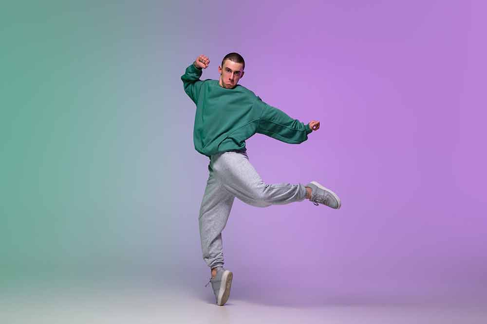 boy-dancing-hip-hop-in-stylish-clothes-on-gradient-background-at-dance-hall-in-neon-light