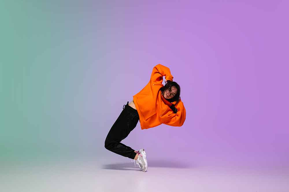 girl-dancing-hip-hop-in-stylish-clothes-on-gradient-background-at-dance-hall-in-neon-light-(1)