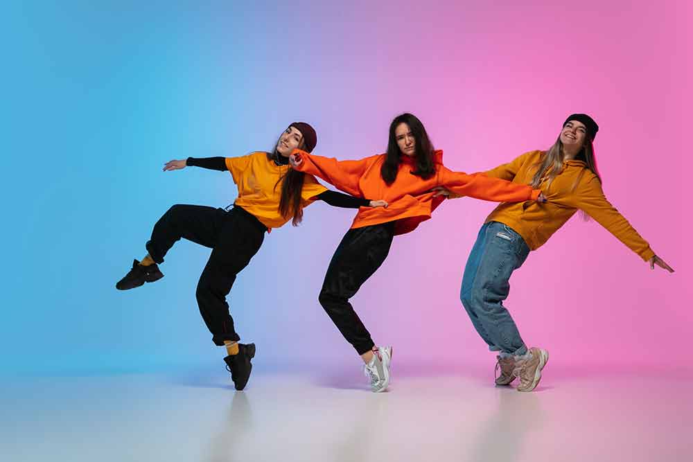 girls-dancing-hip-hop-in-stylish-clothes-on-gradient-studio-background-in-neon-light
